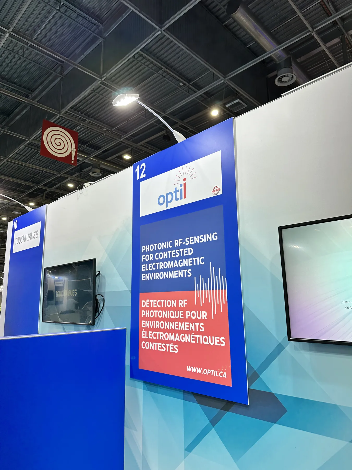 Optii Eurosatory Lab signage describing photonic RF sensing for contested electromagnetic environments.