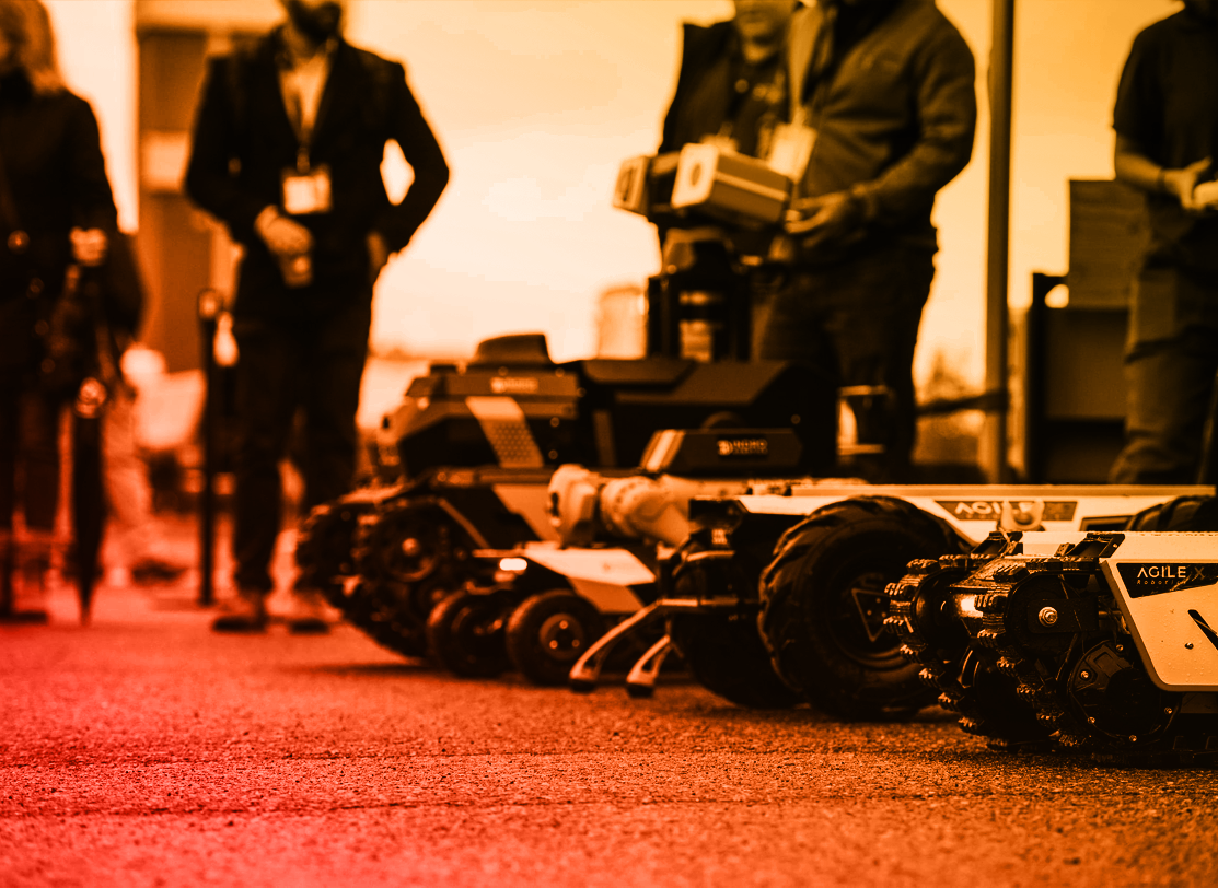 Robotic platforms on display in an orange-toned event photograph supplied in the GCXpo 2026 social media kit.
